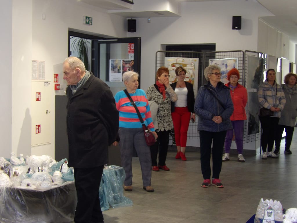 uczestnicy oglądający prace malarskie i ceramiczne