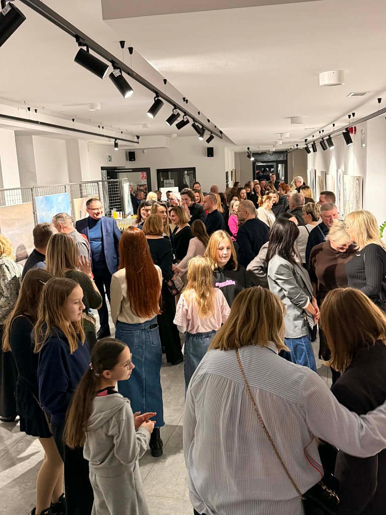 ludzie podziwiający obrazy namalowane przez Marię