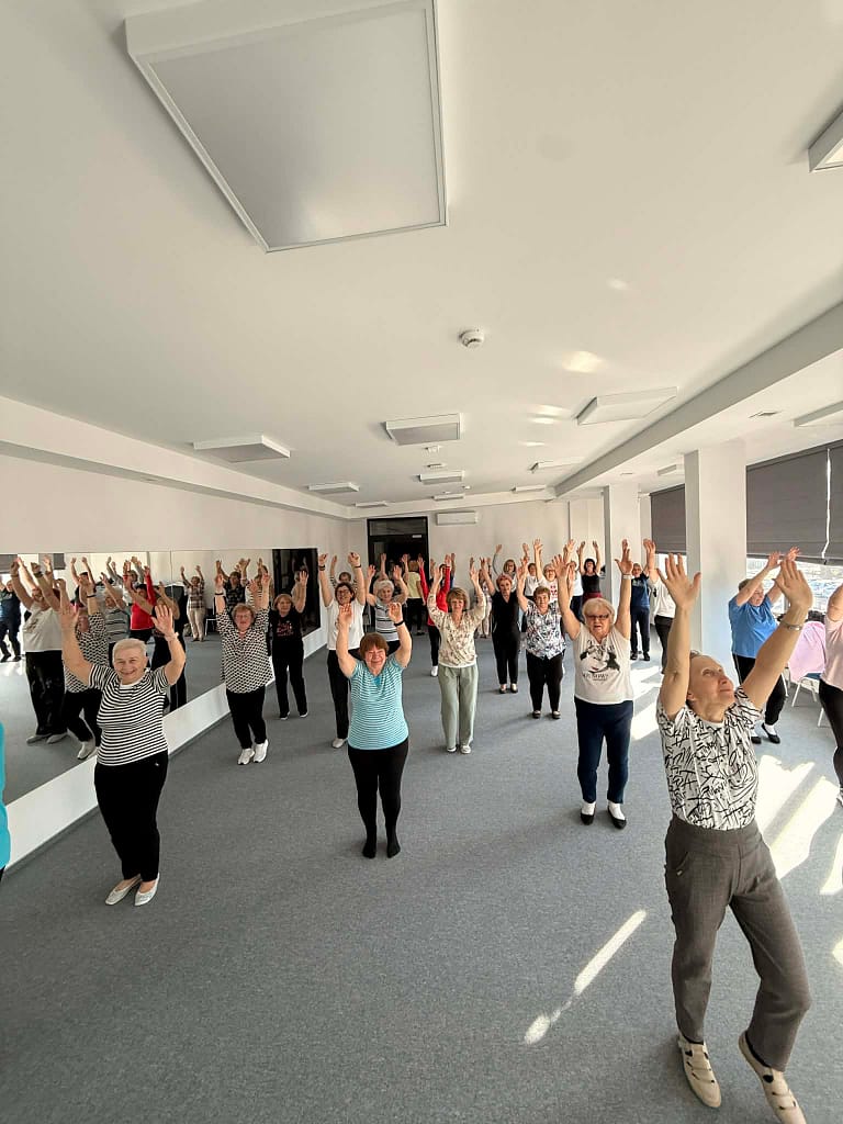 seniorzy ćwiczą na sali rekreacyjnej